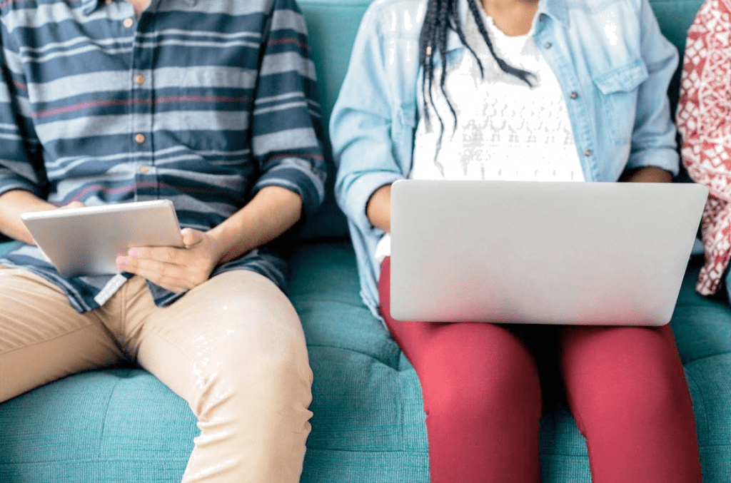 An image of 2 guys using a laptop and tablet.