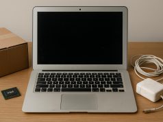 Used MacBook with scratched surface and worn keyboard on a desk, highlighting device condition.