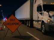 Florida DUI checkpoint sign near commercial trucks, highlighting laws for commercial drivers