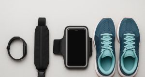 Running shoes, fitness tracker, water bottle, and armband displayed for beginner runners
