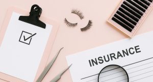 Accredited lash academy classroom with certification materials and industry insurance documents