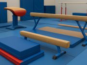 From Mats to Beams: Choosing the Right Training Equipment for Your Gymnast Colorful gymnastics mats and balance beams arranged in a bright, well-equipped gym training area.